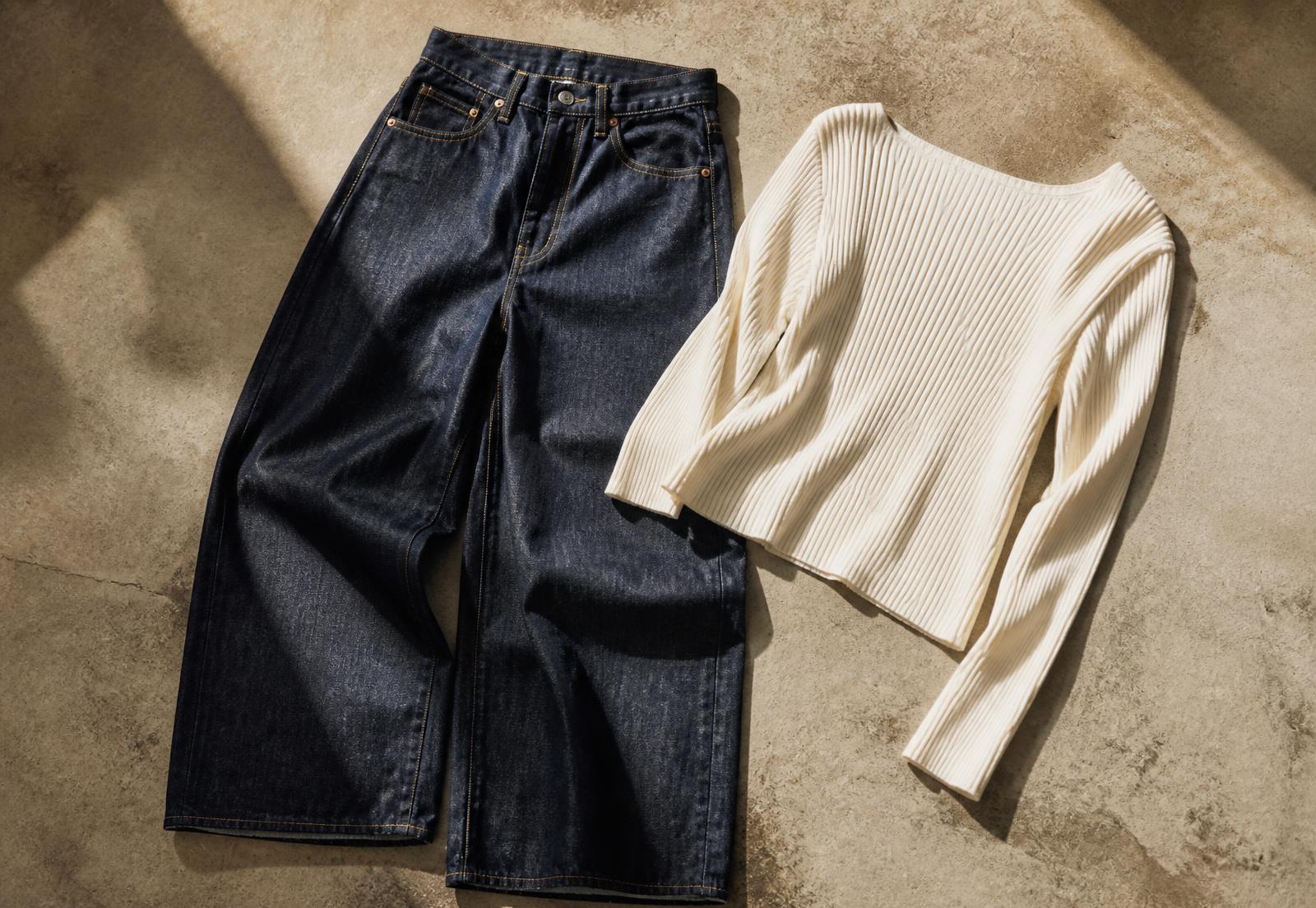 Dark indigo wide-leg jeans laid beside a cream rib knit top